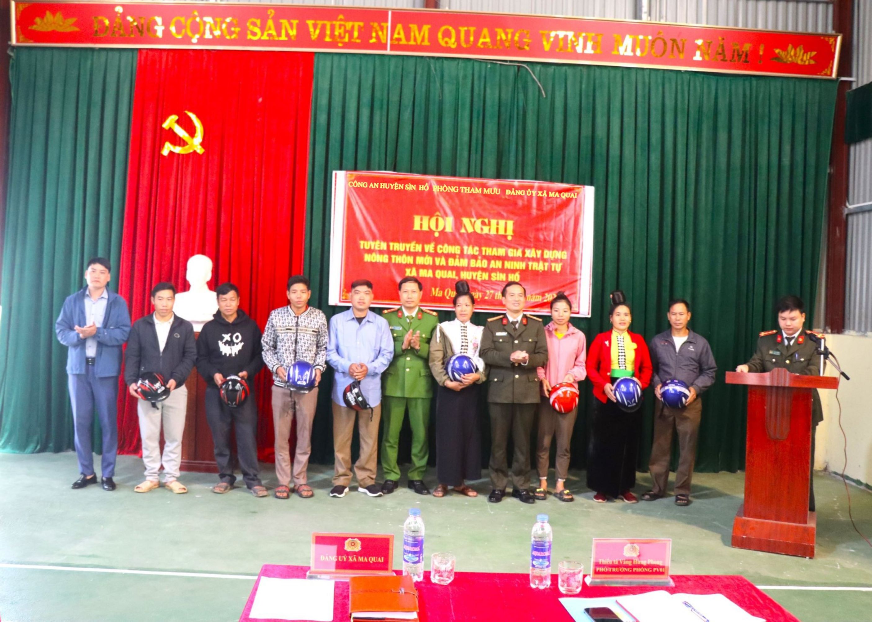 Đại diện Phòng Tham mưu (Công an tỉnh), Công an huyện, Đảng ủy xã Ma Quai tặng mũ bảo hiểm cho người dân.