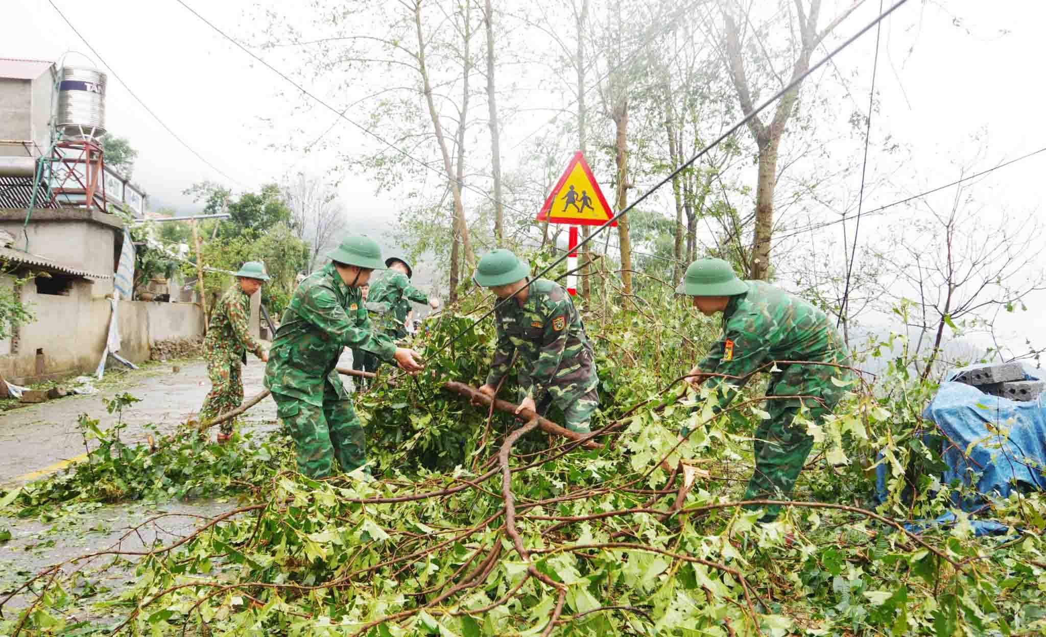 Cán bộ, chiến sĩ Đồn Biên phòng Sin Suối Hồ giúp nhân dân xã Sin Suối Hồ khắc phục hậu quả thiên tai. 